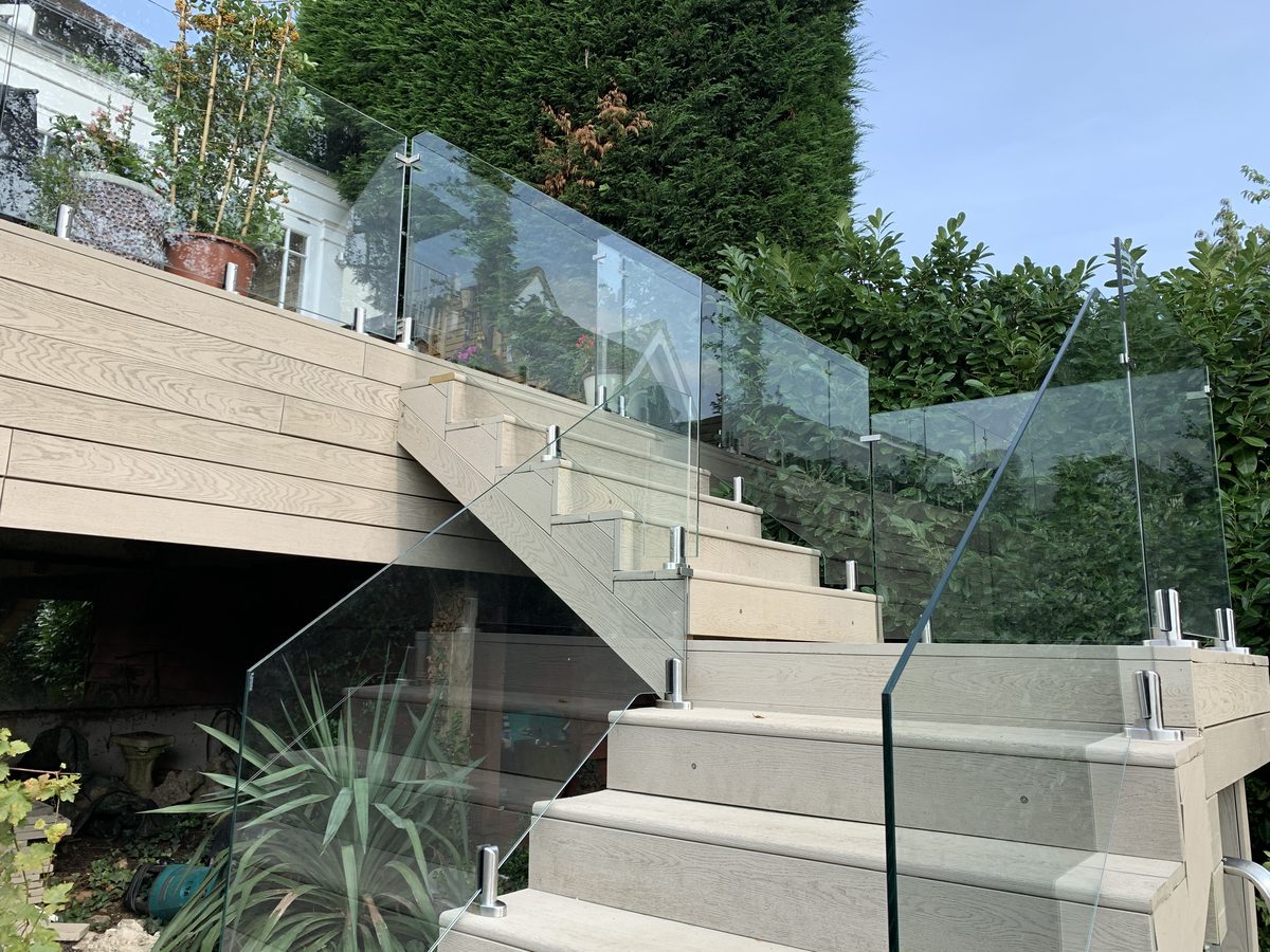 Frameless glass balustrade fitted to garden steps and a raised terrace