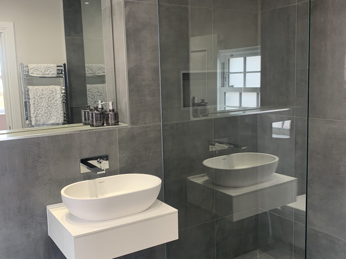 Mirrored glass and a frameless shower screen fitted in a bathroom